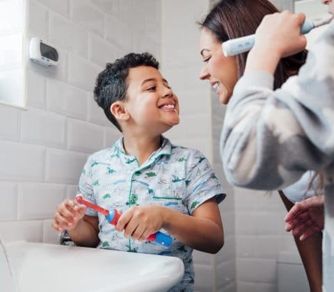 A child brushing their teeth with an electric toothbrush