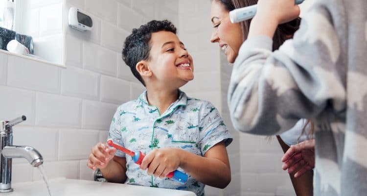 A child brushing their teeth with an electric toothbrush