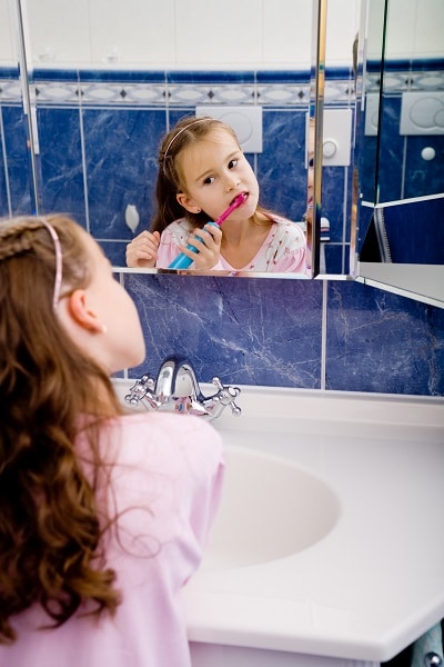 Girl using electric toothbrush