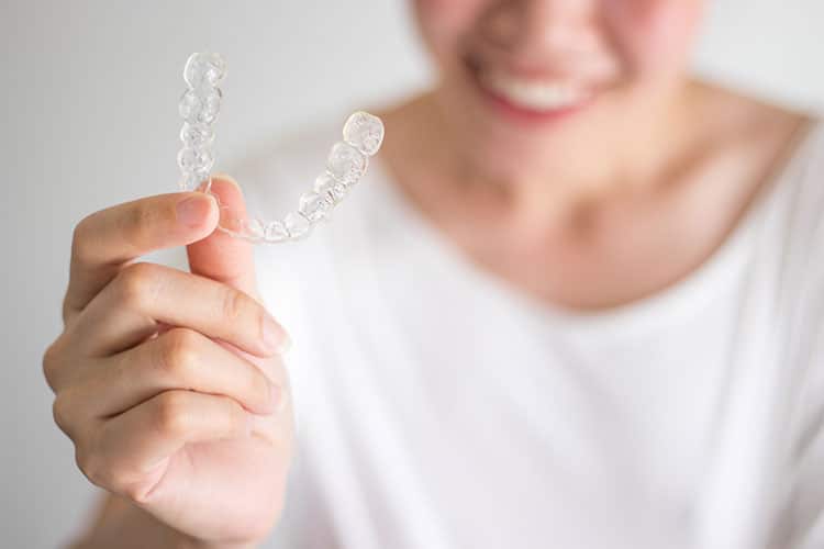 woman holding invisalign