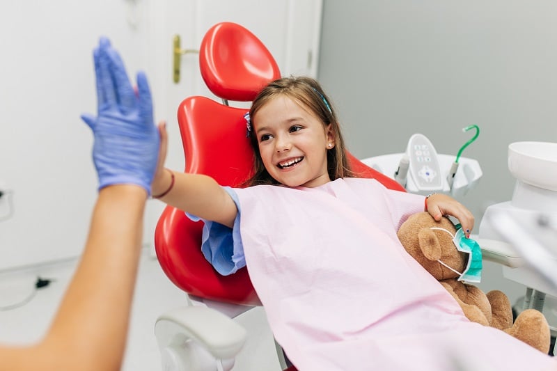 A child using toys to overcome her anxiety at the dentist