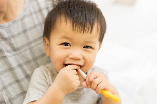 A baby brushing their teeth