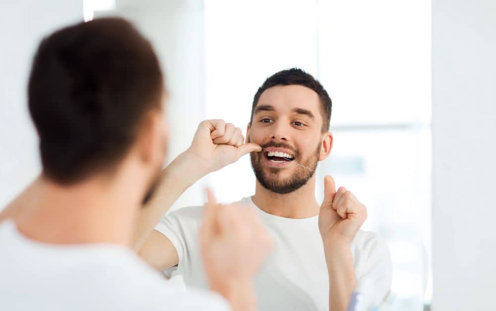 Man flossing his teeth.