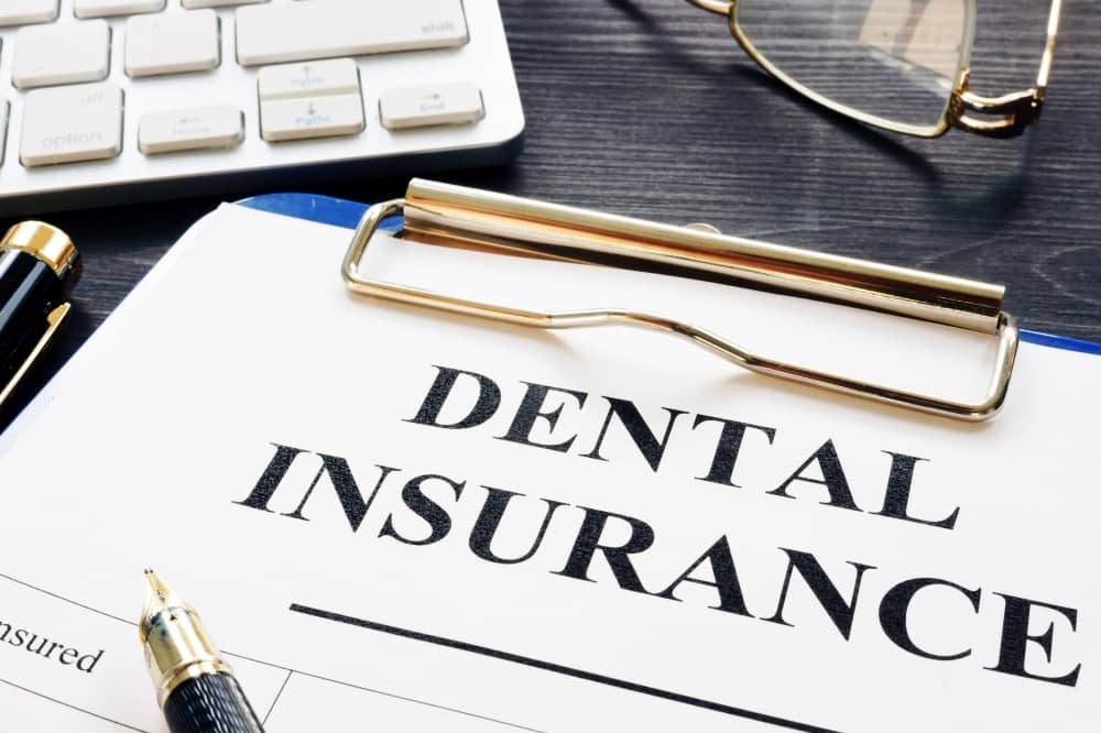 Dental insurance document on a clipboard.