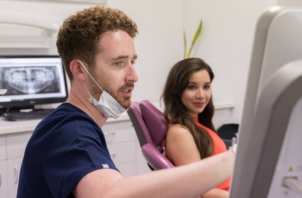 Dentist showing results to patient in dental monitor.