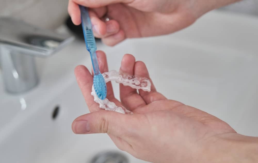 Keeping your Invisalign trays clean and free from bacteria is essential. Brush them with a soft-bristled toothbrush and toothpaste every day.