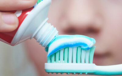 adding toothpaste to toothbrush