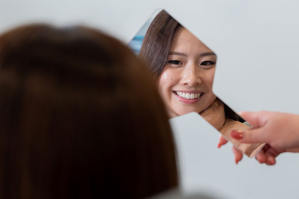 smiling patient at dentist with mirror