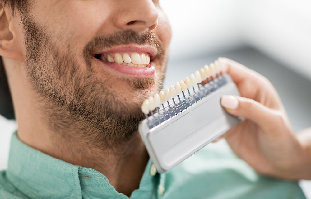 dentist colour matching veneers to patients teeth