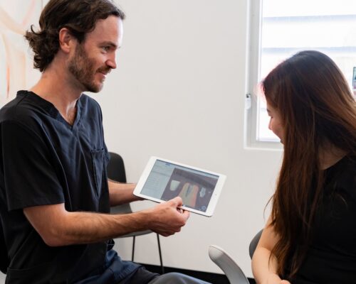 dental-implants-perth dentist showing dental implant to patient