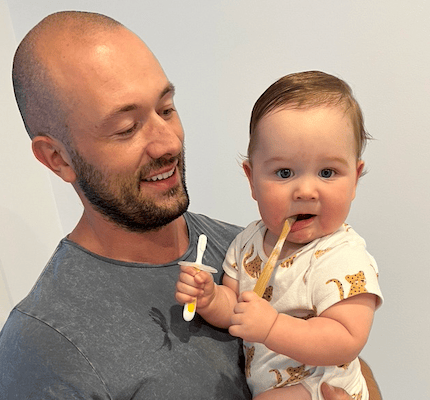 baby with tooth bursh in her mouth