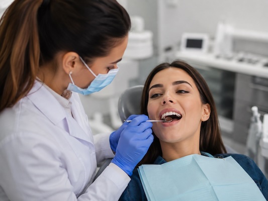 Dentist checking a patient’s teeth and gums for signs of common dental problems.